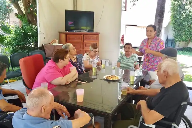 Adultos mayores tomando café en la terraza de Residencia Oasis Cuernavaca
