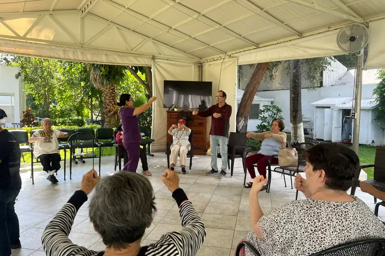 Clase de activación física para adultos mayores en la palapa del jardín de Residencia Oasis Cuernavaca