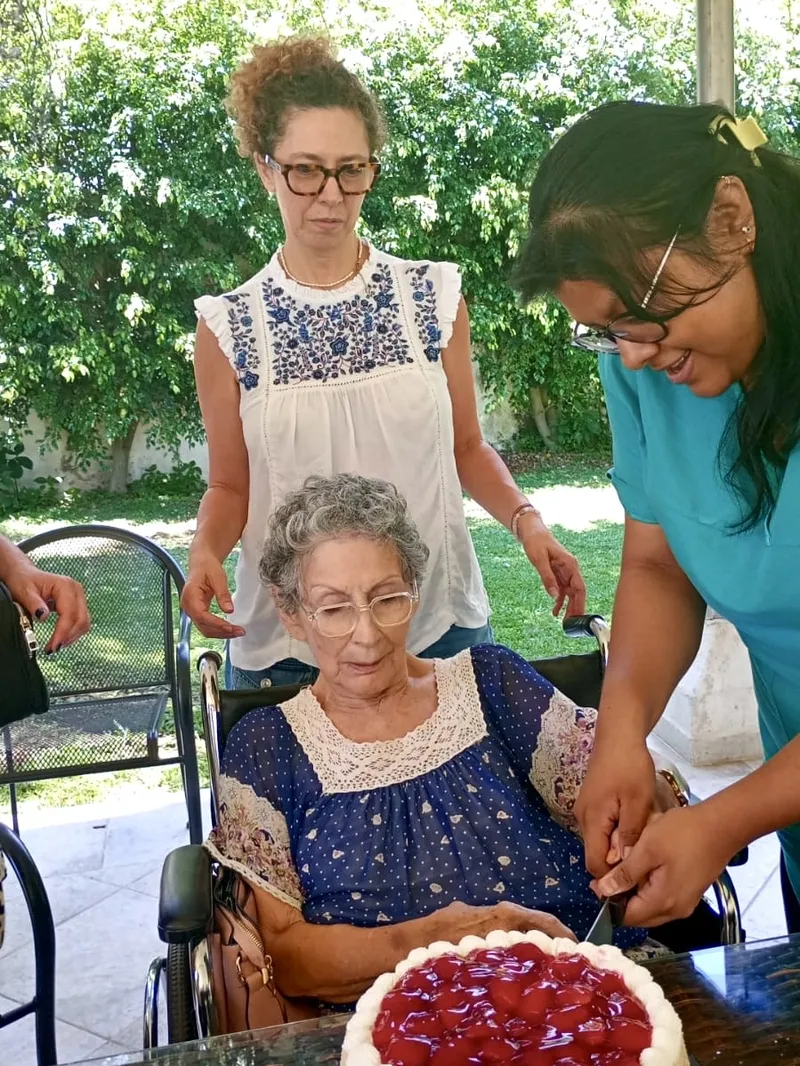Residente celebrando su cumpleaños con pastel de fresas en el jardín de Oasis Cuernavaca