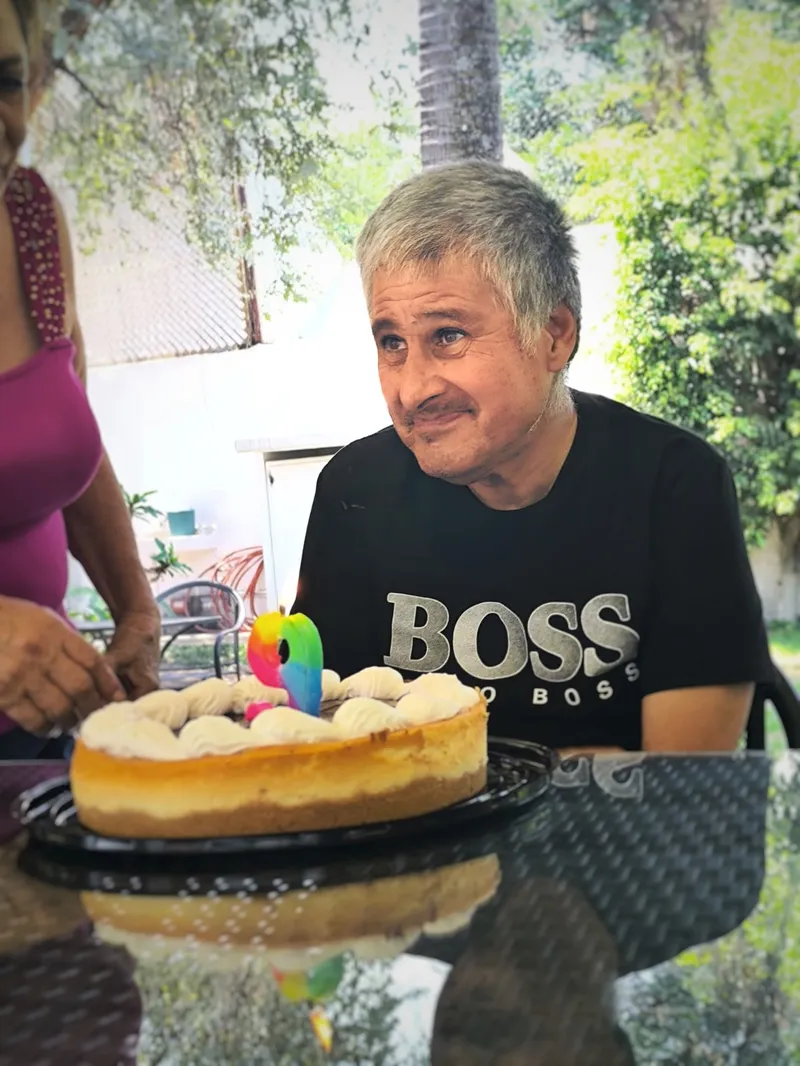 Residente sonriendo junto a su pastel de cumpleaños en la terraza de Oasis Cuernavaca
