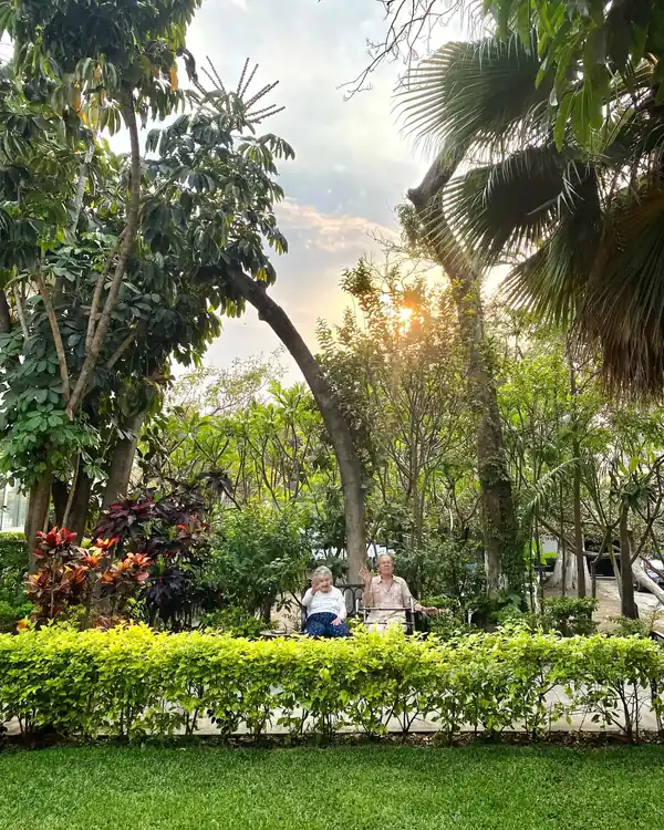 Dos adultos mayores conviviendo al atardecer en el jardín de Residencia Oasis Cuernavaca