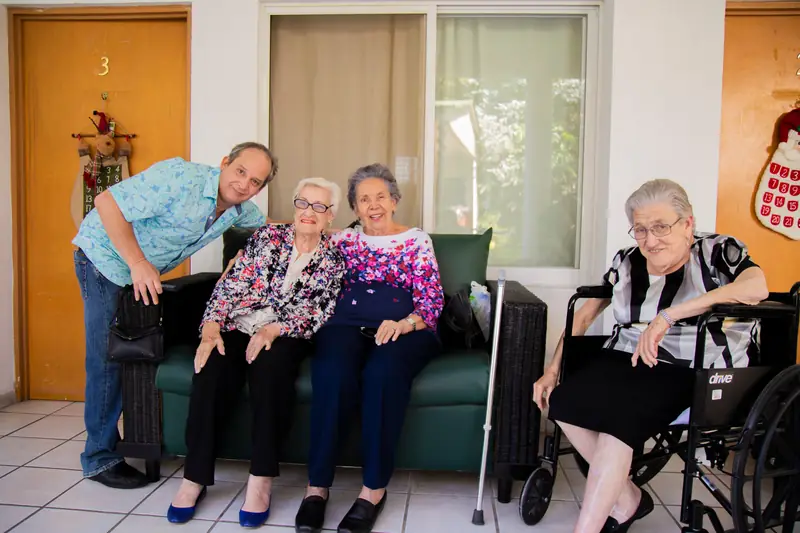 Residentes conviviendo con un familiar en la terraza de sus habitaciones en Oasis Cuernavaca