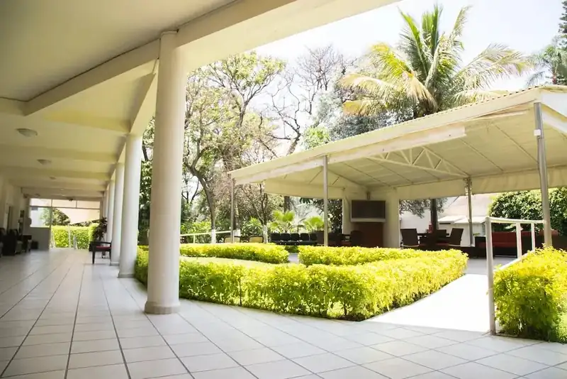 Corredor y terraza cubierta con acceso al jardín en la residencia para adultos mayores Oasis Cuernavaca